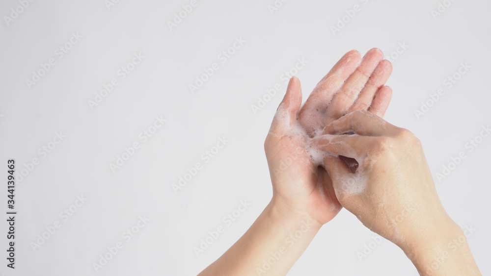 Male model is rub fingertips of one hand on the other plam foaming hand soap on white background.