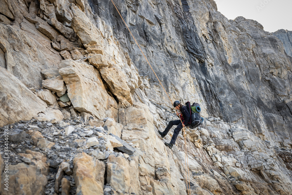 Man Rappelling from Cliff