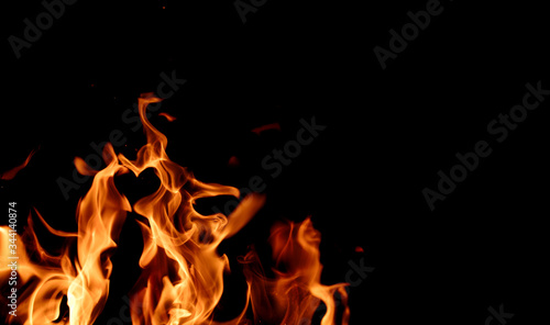 Bright fiery symbol on a black background. Fire background. Fire flame on a black background.