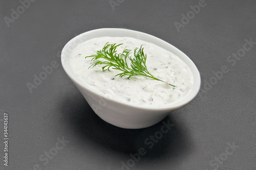 White ceramic bowl with white souce on grey background