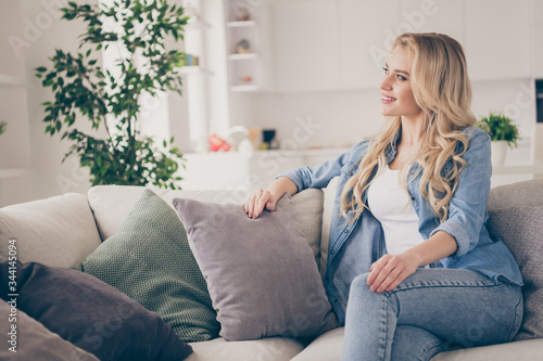 Photo of domestic pretty charming blond lady relaxing sit comfy couch staying home good mood dreamer quarantine time lighted living room indoors