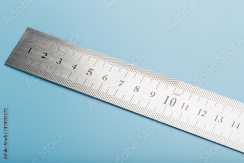 Fotografía Metal ruler on a blue background close-up with a copy of the space for your text