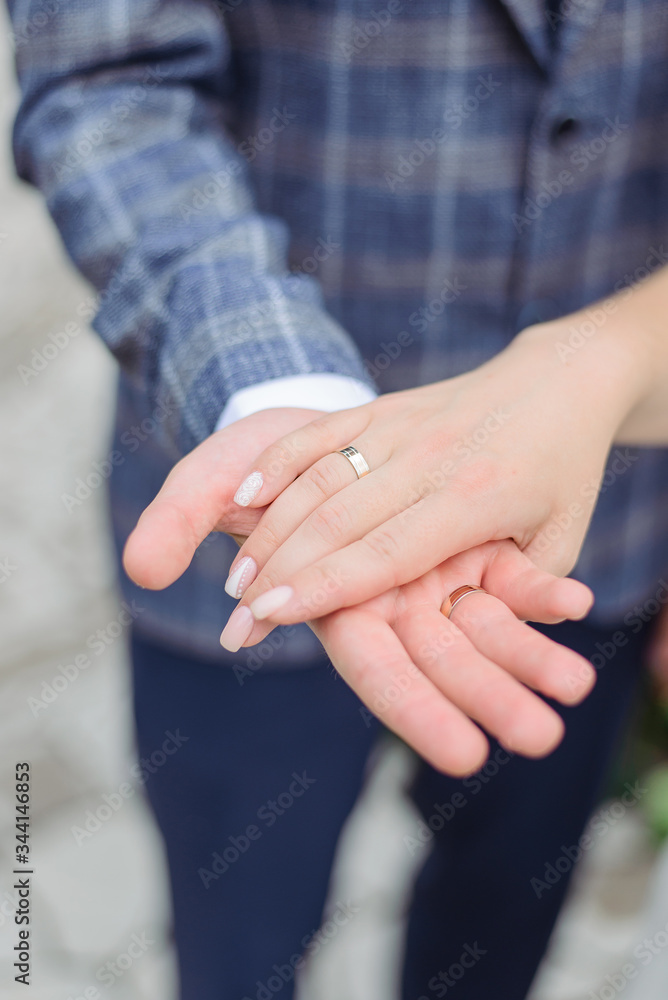 Hands of newlyweds in love. The groom gives his palm to the bride.