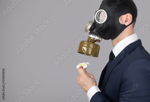 Close up portrait of man in a protective gas mask with flower photo