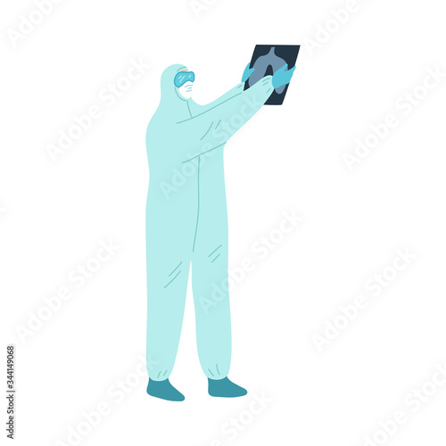 Doctor in uniform standing and holding fluorogram in hands during pandemic