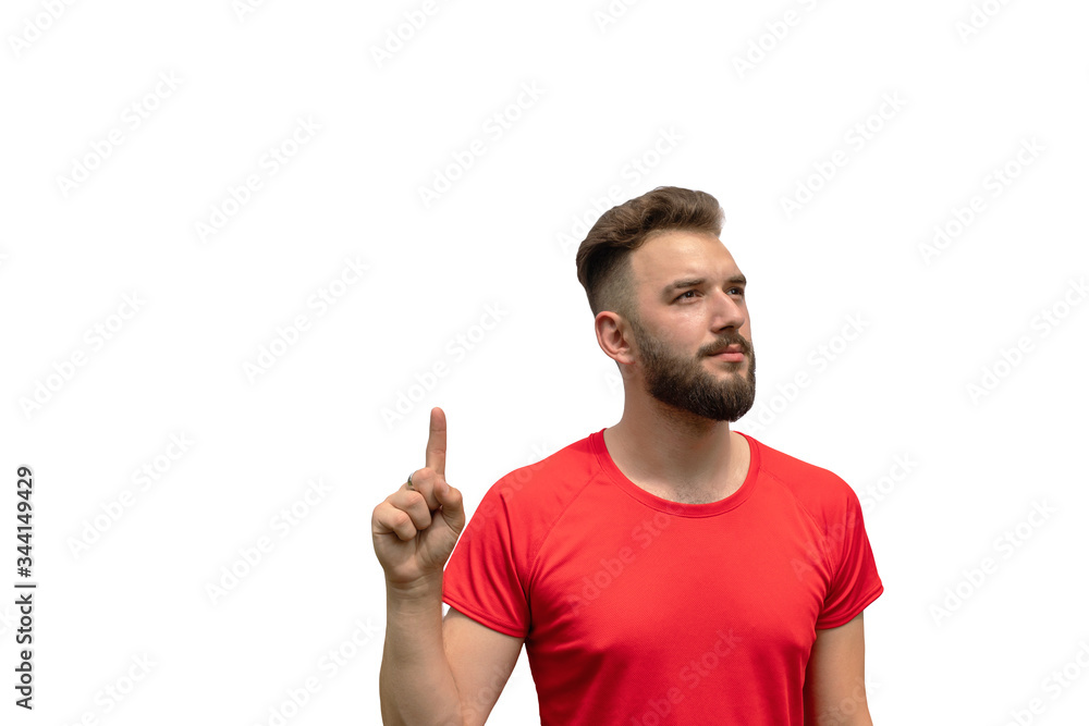 Naklejka premium handsome young man in red t-shirt points finger up isolated on white background. pay attention, way up, look up