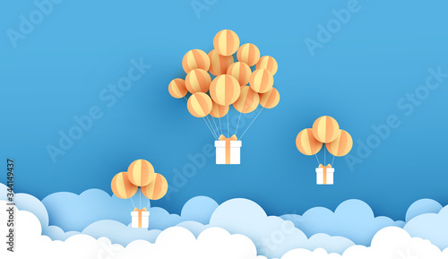 Balloons yellow floating on sky. Delivery service with Gift Box on air blue background.happy new years and merry Christmas.Festival transportation concept.Creative paper cut and craft style vector