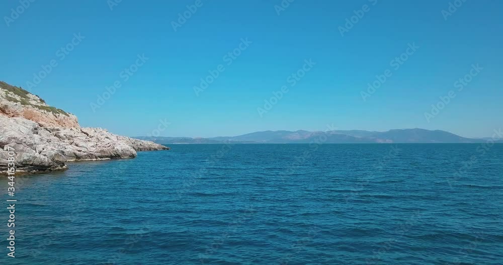 Forward low altitude aerial shot next to a rocky shore over the aegean sea with a view of Euvoia. 4K video quality Forward low altitude aerial shot next to a rocky shore over the aegean sea with a view of Euvoia. 4K video quality