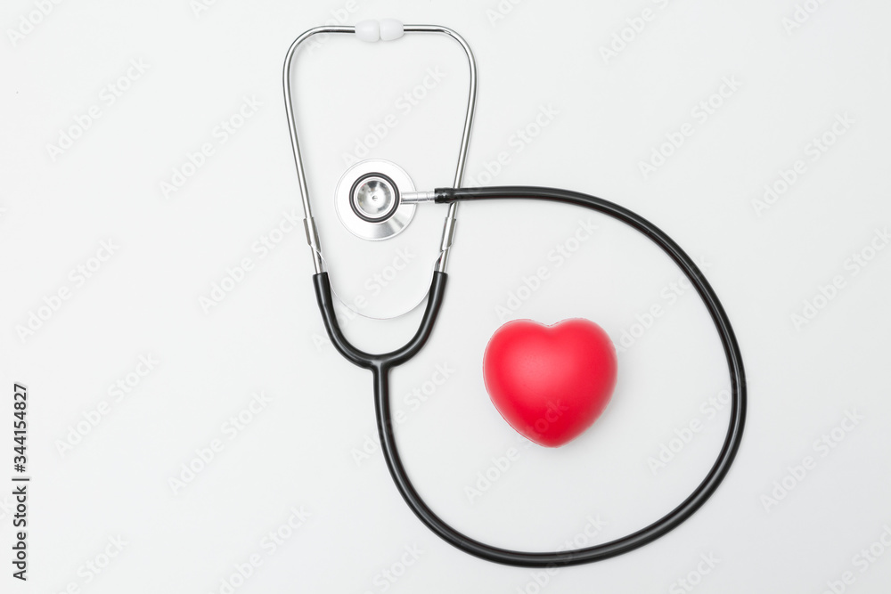Top view of Heart shaped squeeze ball for hand muscle exercise and stethoscope on white background Top view of Heart shaped squeeze ball for hand muscle exercise and stethoscope on white background