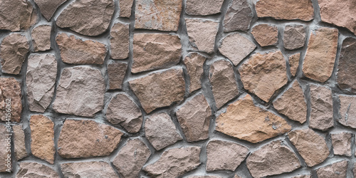 Brown stone wall texture, floor background. Wide panoramic rock pattern. Natural masonry surface, brick frame. Grunge structure. Design element.