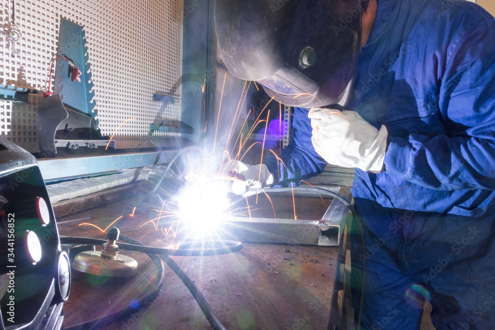 Worker welding metals on the job Worker welding metals on the job
