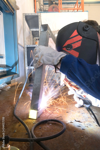 Worker welding metals on the job