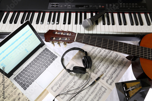 equipment for recording music in the studio, piano, guitar, microphone, headphones, laptop