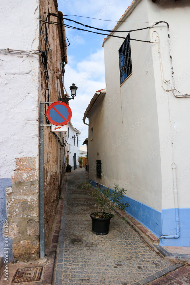 narrow cosy street with the flower pot in the old town of sagunto in spain