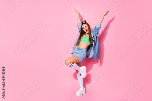 Full length body size view of nice attractive tanned slim fit slender overjoyed ecstatic cheerful cheery girl having fun dancing rising hands up season wear isolated over pink pastel color background © deagreez