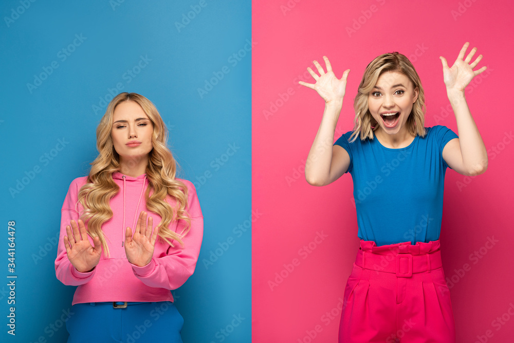 Φωτογραφία Blonde woman showing stop sign near excited sister on pink and blue background