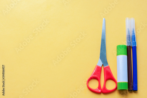 On a yellow background scissors glue and markers. Concept Diy.Step by step instructions.