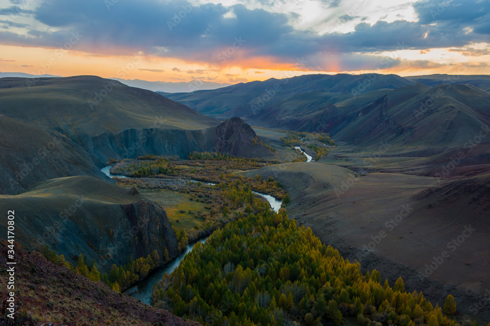 Sunset, winding river against the background of mountains and autumn trees, Altai