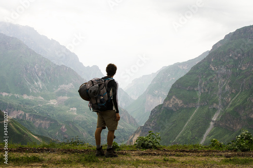 Fotografie Senderista joven de espaldas observando las montañas en el Cañon del Colca en Pe