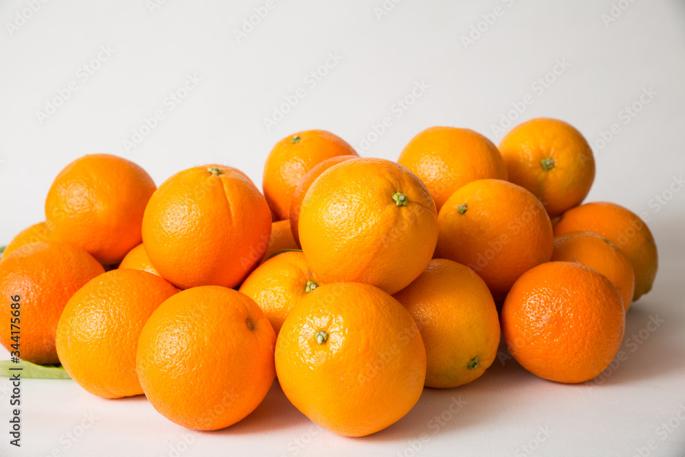 Whole orange fruits pile isolated on white background. Side view, closeup. Natural vitamin or organic food concept Whole orange fruits pile isolated on white background. Side view, closeup. Natural vitamin or organic food concept