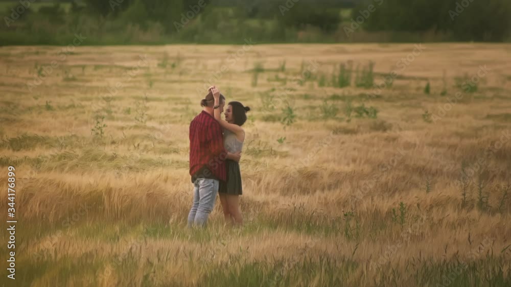 lovers man and woman travel in the field holding hands. Follow me, a young happy couple running along golden wheat field. happy family concept. beautiful girl hug her boyfriend. hand in hand lovers man and woman travel in the field holding hands. Follow me, a young happy couple running along golden wheat field. happy family concept. beautiful girl hug her boyfriend. hand in hand