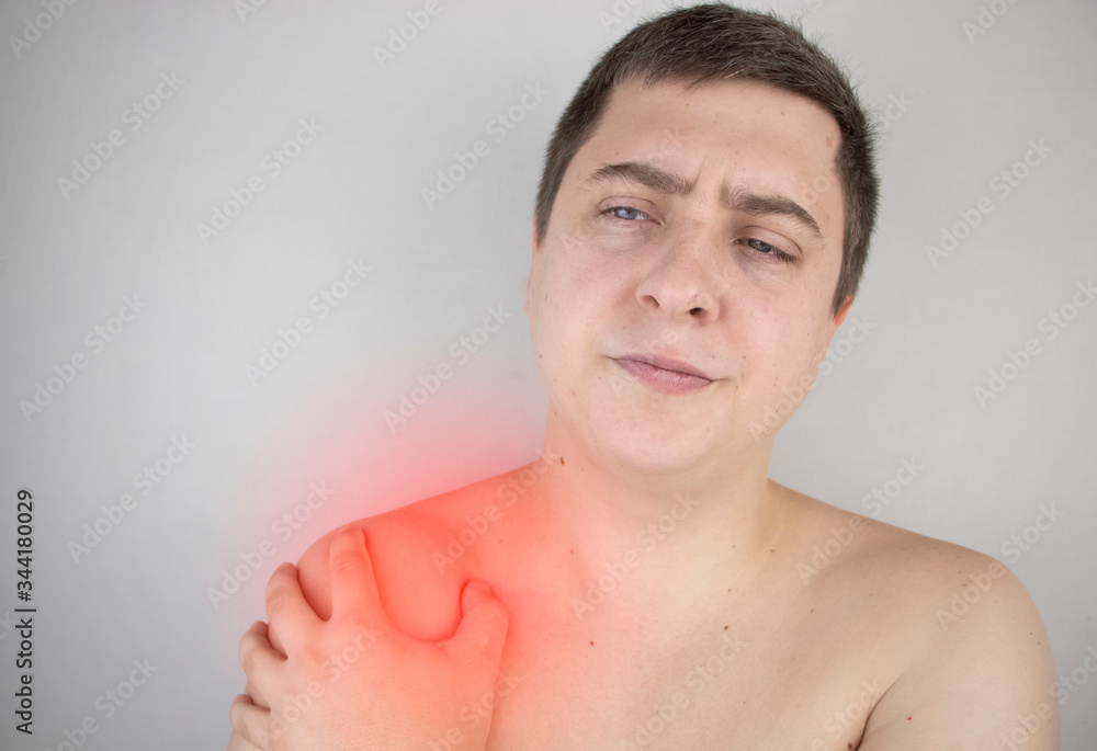 Obraz premium A man suffers from shoulder pain. Shoulder injury, tendonitis, sprain, or tendon inflammation. The concept of acute pain and inflammation in different parts of the body