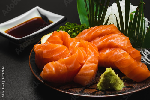 Sashimi, Salmon, Japanese food chopsticks and wasabi on the wood table