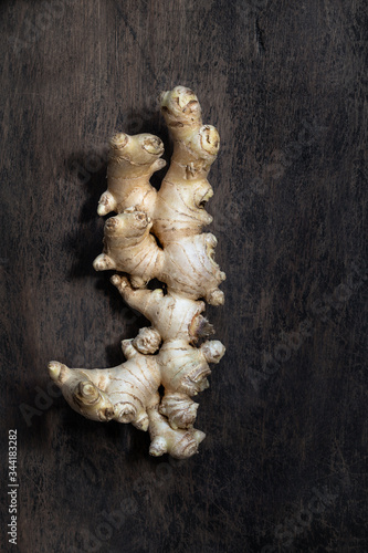 Fresh organic ginger root on dark old rustic background with copyspace top view.