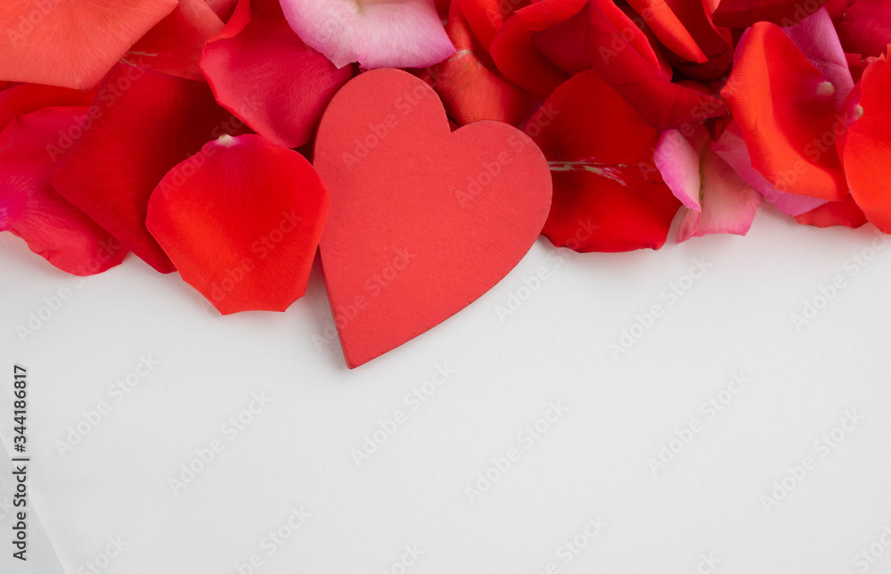 On the red rose petals is a red wooden heart.Concept of mother's Day, family Day, Valentine's Day, March 8