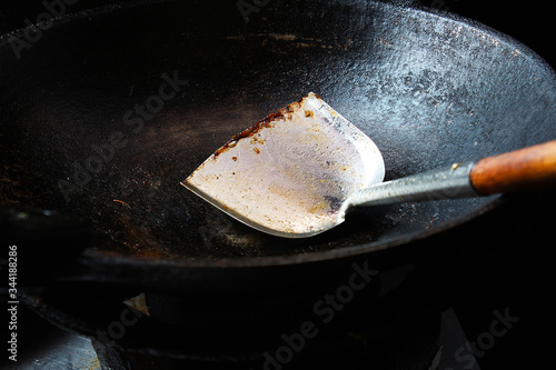 Old black iron pan and spade of frying pan with food scraps stuck