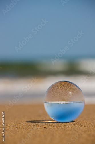 海の海岸にある透明な水晶ガラスボール