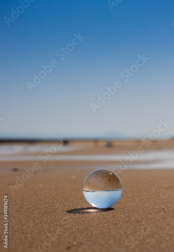 海の海岸にある透明な水晶ガラスボール