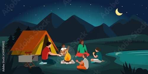 Happy family camping in the forest at night