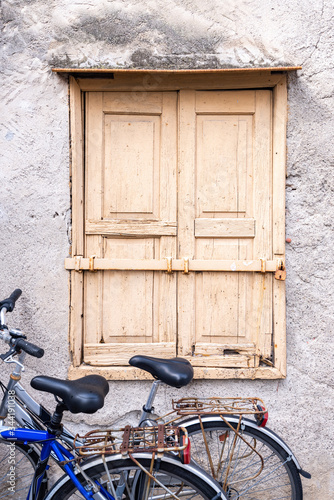 Eine Hausmauer mit alten Holzfensterläden und zwei Fahrräder als Hintergrund © Olaf Wandruschka