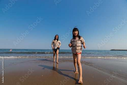 海岸で海遊ぶをしている子供姉妹