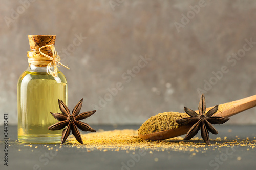 Glass bottle of anise essential oil with anise star and powder, spice oil concept, ( Pimpinella anisum ) photo