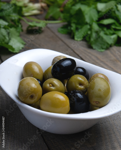 Green and black olives on wooden surface. Olives in wooden background 