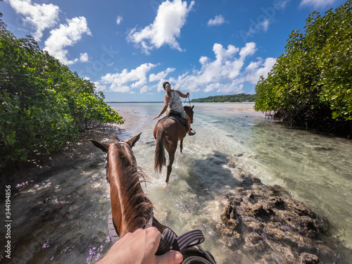 horse riding in blue lagoon sunny day turquoise water Esparto Santo island Vanuatu