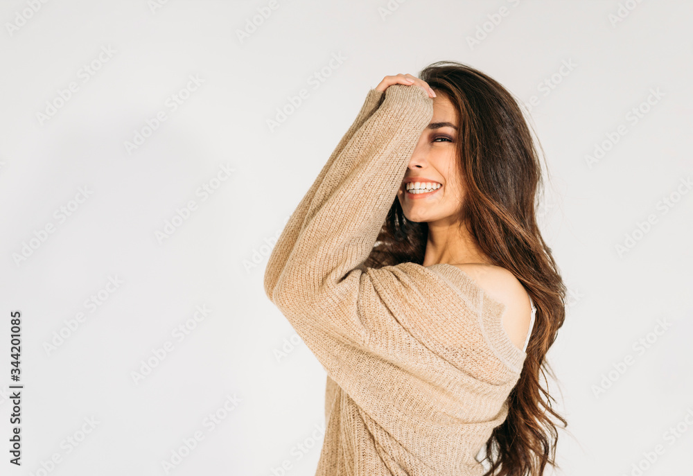 Charming smiling asian girl with long brownw hair in beige sweater looking at camera isolated on the white background Charming smiling asian girl with long brownw hair in beige sweater looking at camera isolated on the white background