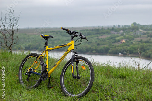 Yellow bicycle on green grass by the river