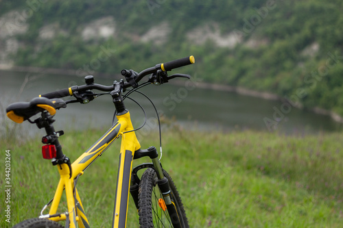 Yellow bicycle on green grass by the river