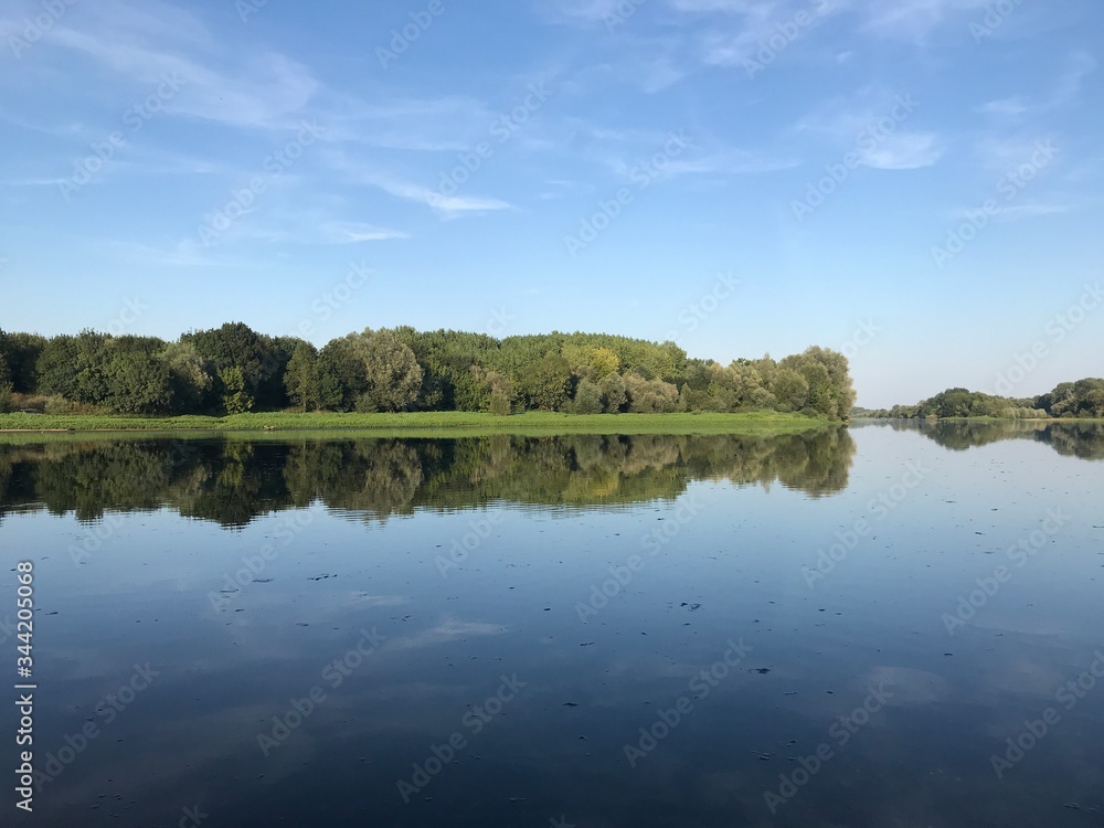 Obraz premium reflection of trees and sky in the river Loire, France