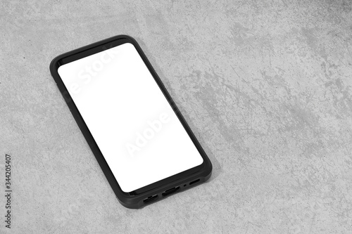 Smart phone with white screen isolated on textured concrete background. Mock up template. Copy space
