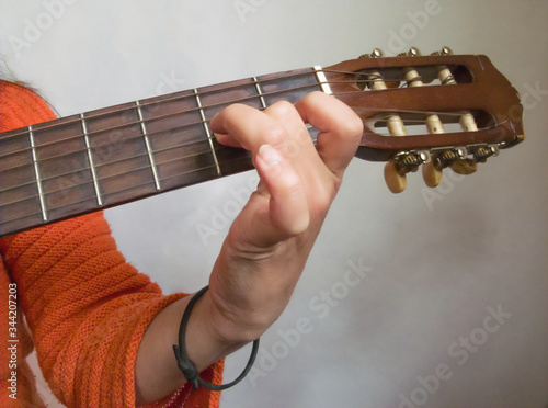 woman playing an acoustic guitar, hand is visible close-up