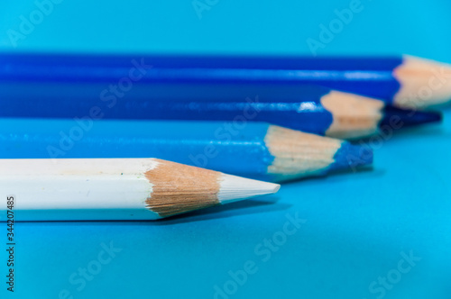 white pencil on blue background