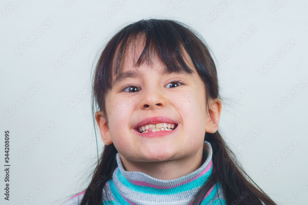Portrait of a cheerful child with long hair and a striped sweater. girl fooling around Portrait of a cheerful child with long hair and a striped sweater. girl fooling around