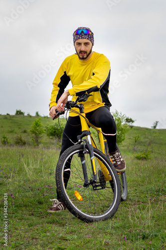 A cyclist sits on a bicycle and looks into the camera