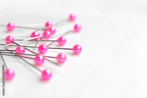 Pink needle pin on white background close-up.