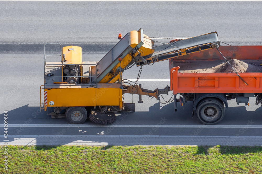 Obraz premium Trailer with cleaning system with brushes and vacuum cleaning, roadside cleaning in the city.