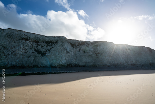 Chalk cliffs at Escalles on the Opal coast in northern France close to Cap Blanc Nez with sun shining over the edge and blue skies with clouds photo